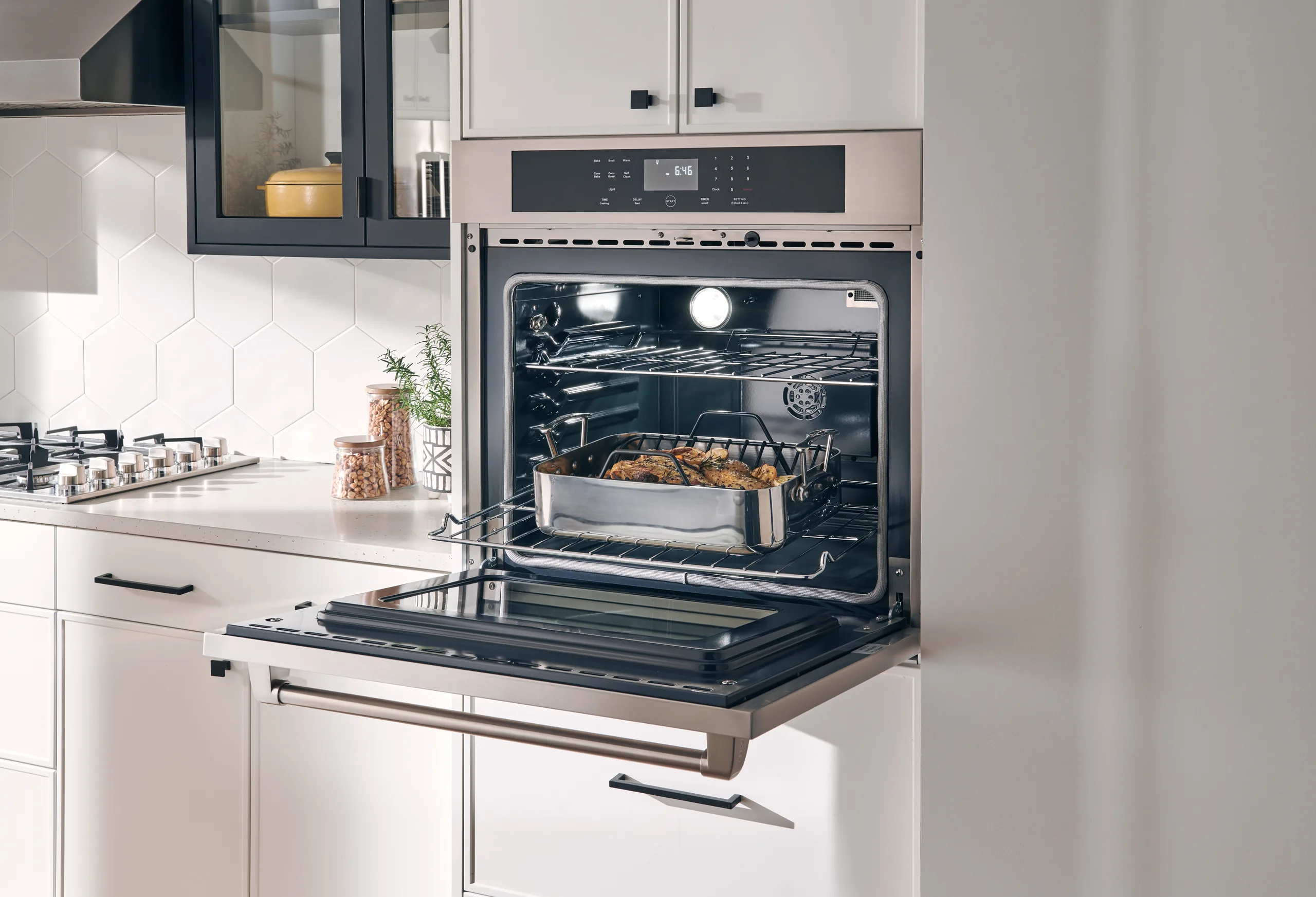 Horno de pared eléctrico Thor Kitchen HEW3001 con alimentos en su interior iluminado y parrillas de acero inoxidable — disponible a través de Artexa México
