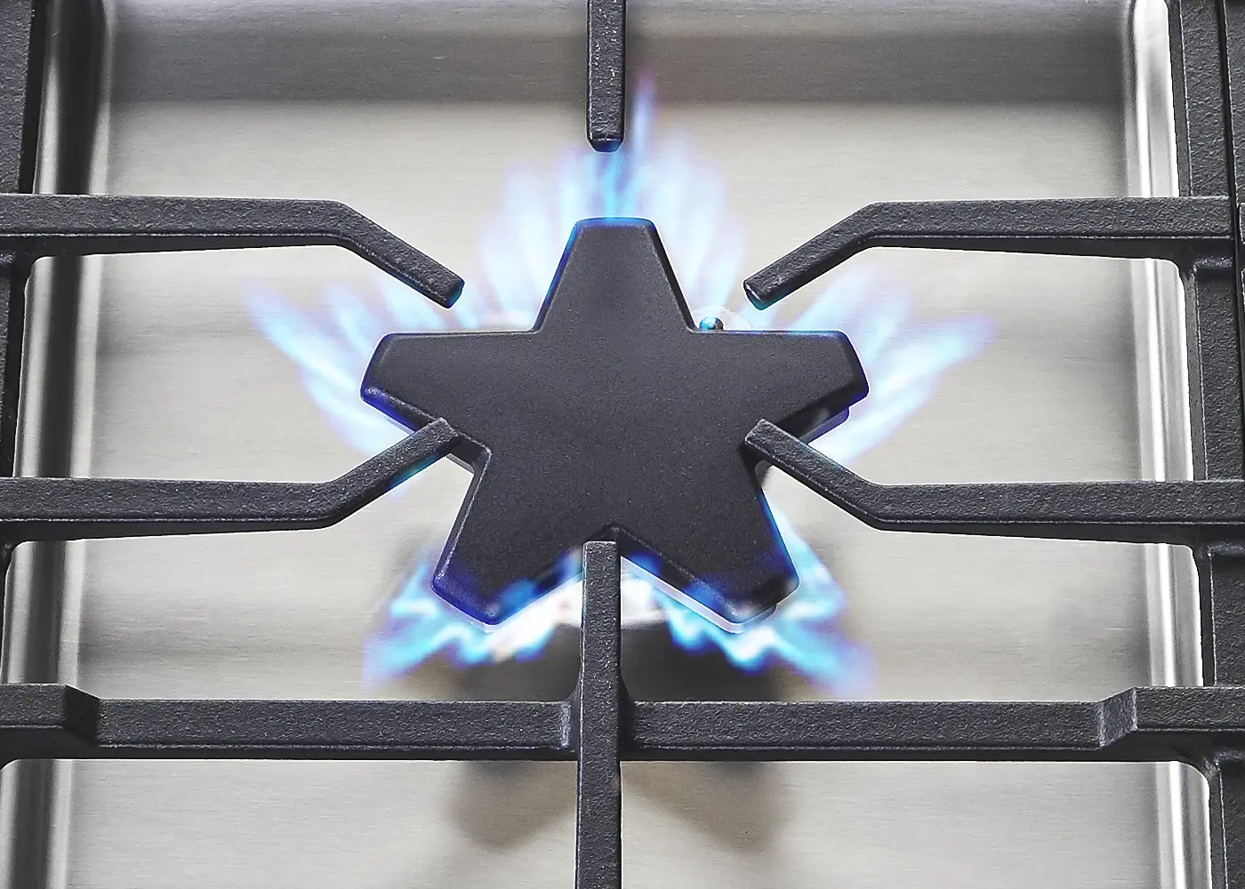Acercamiento cenital del quemador Star® de cinco puntas en una parrilla de gas Thermador, disponible a través de Artexa México