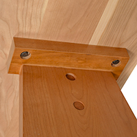 Detailed view of leg construction detail on the bottom of a solid wood console table.