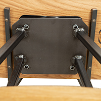 A close up detail of the bottom of a wooden stool that highlights its swivel seat feature.