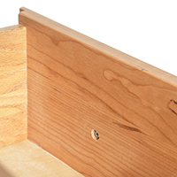 Detailed close-up image of the interior of a solid wood drawer.