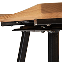 A close up detail of the bottom of a wooden stool that highlights its swivel seat feature.