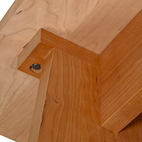 Detailed view of leg construction detail on the bottom of a solid wood console table.