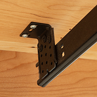 Detailed view of the underside of a soft-close keyboard tray drawer slide and mechanism.