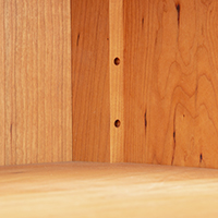 Detailed view of the adjustable shelf construction of a solid wood open console bookcase.