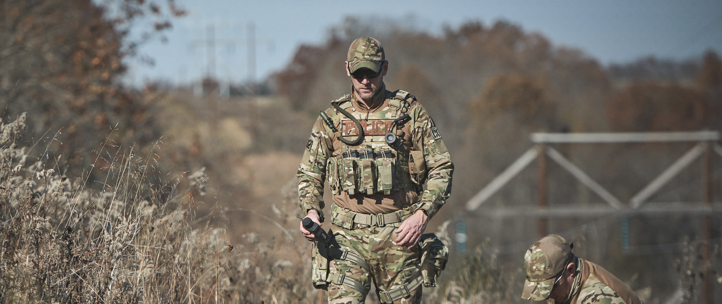 Image of a person in a multicam gunner plate carrier in the woods