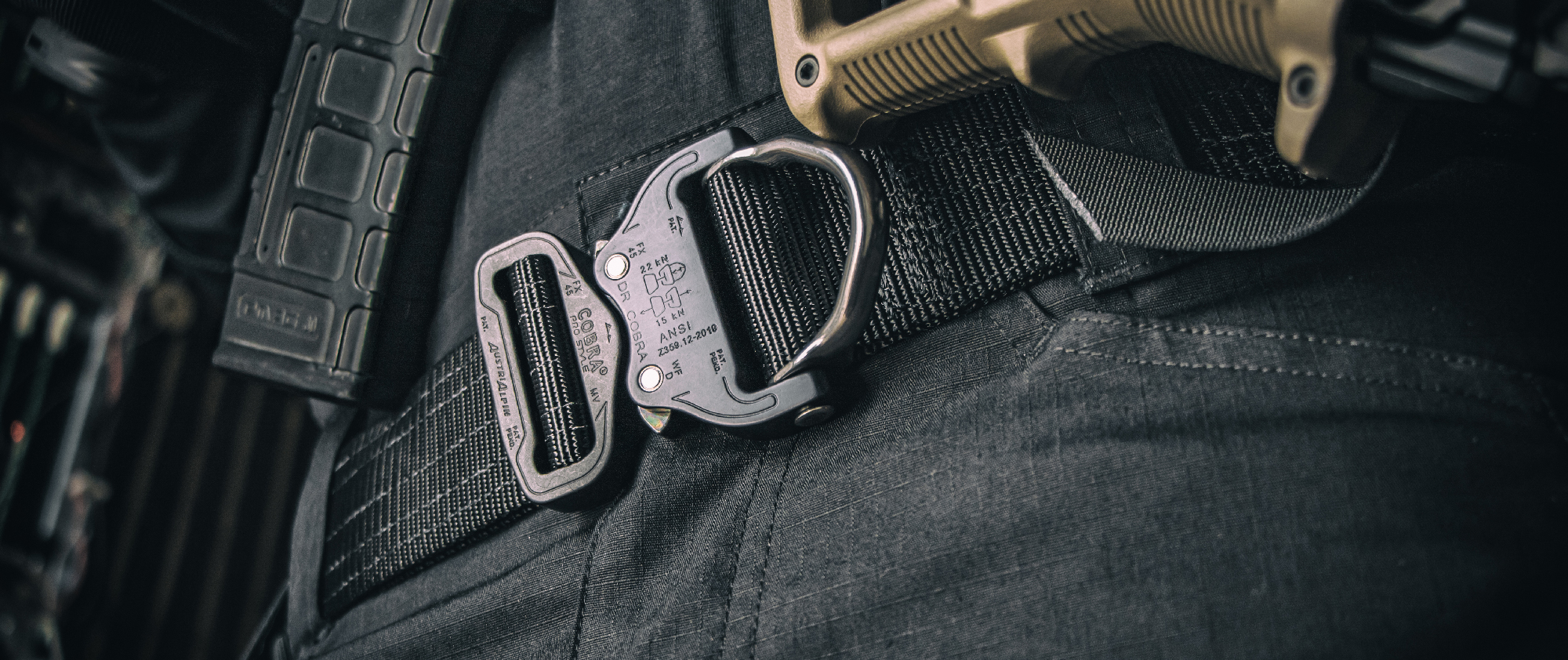 Image of someone in black dress wearing the cobra pro belt while holding a rifle