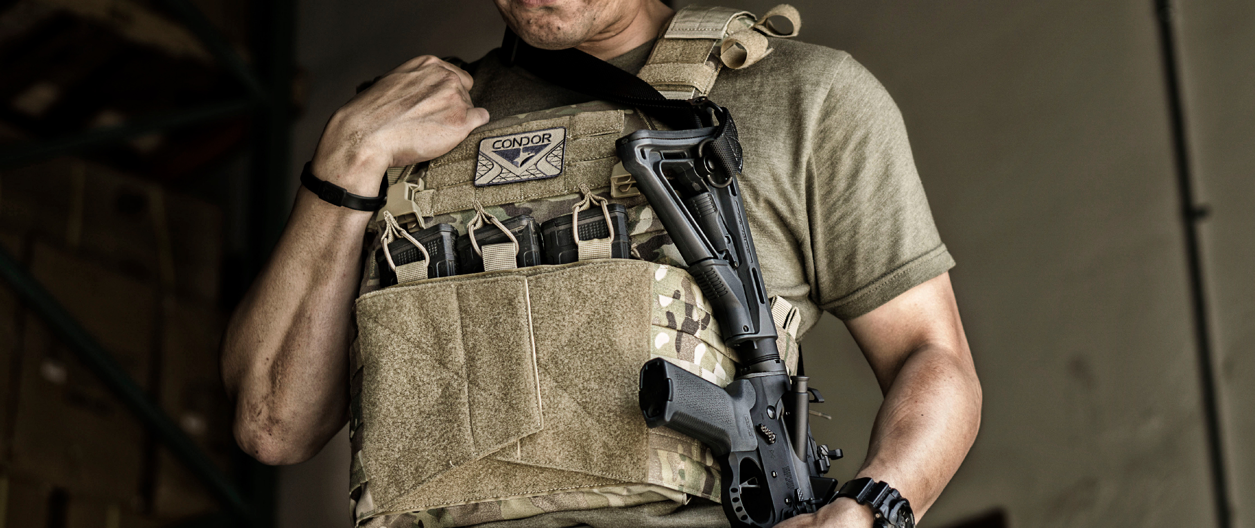 Image of someone witha rifle in civilian clothing wearing a vanquish plate carrier