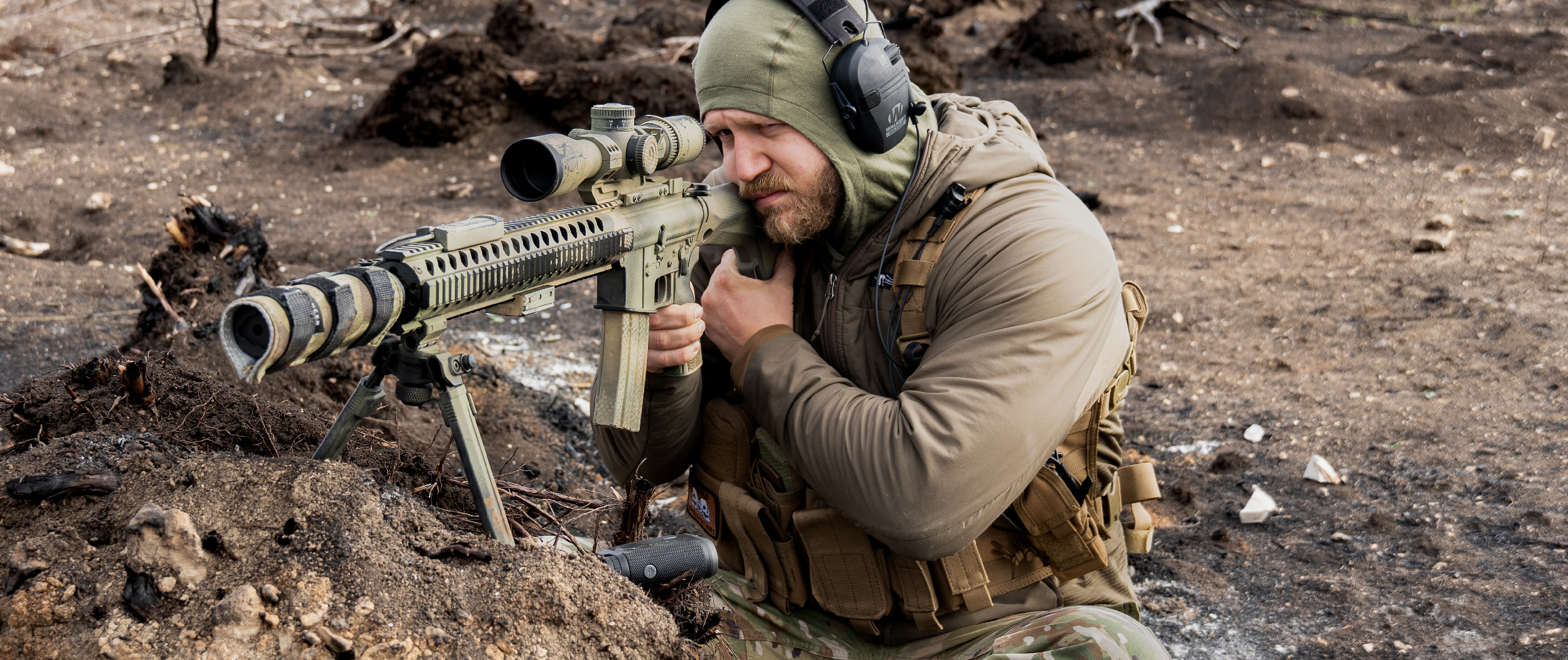 Image of a sniper with a rifle on a berm wearing the recon chest rig