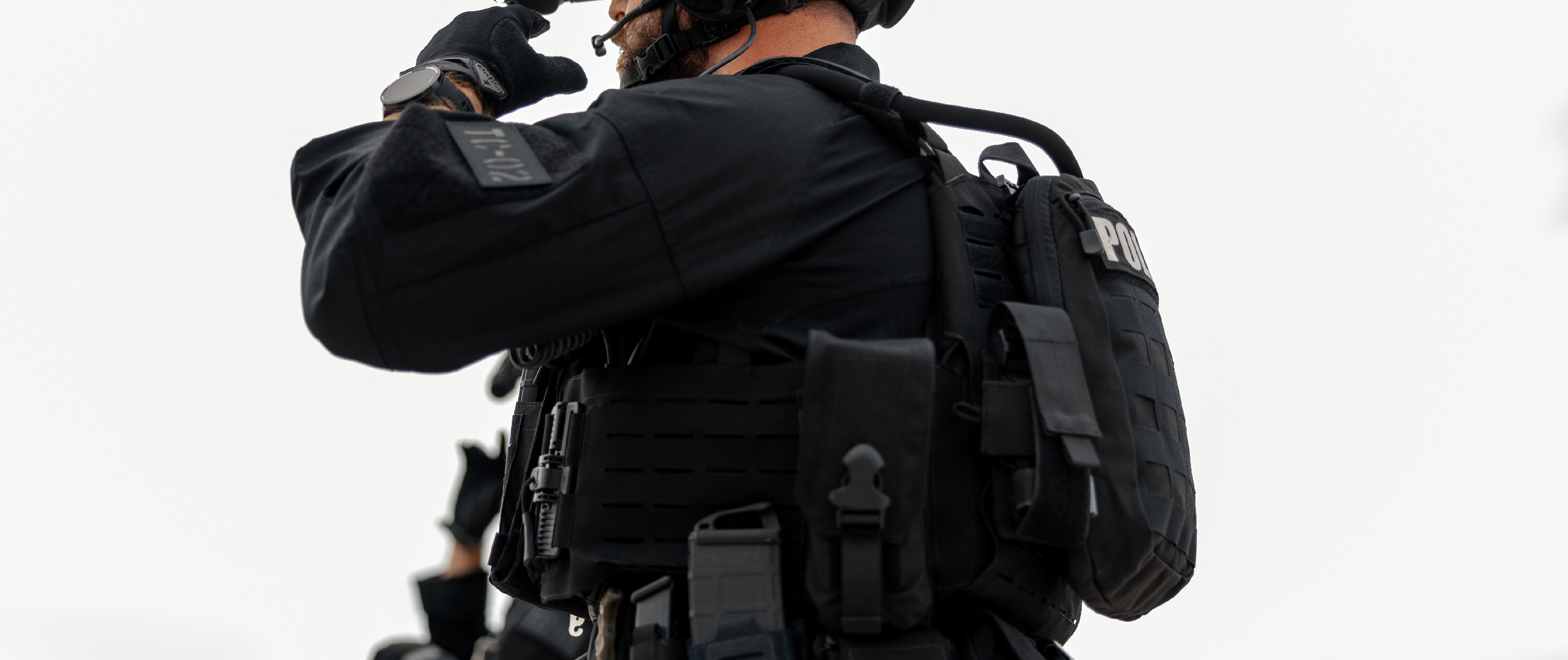 Image of a swat officer wearing full kit with the hydration carrier attached to his plate carrier