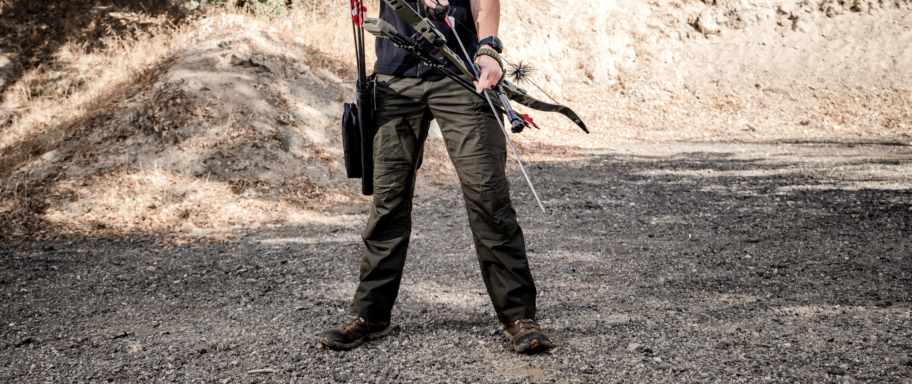 a person holding a bow and arrow wearing the stealth operator pants
