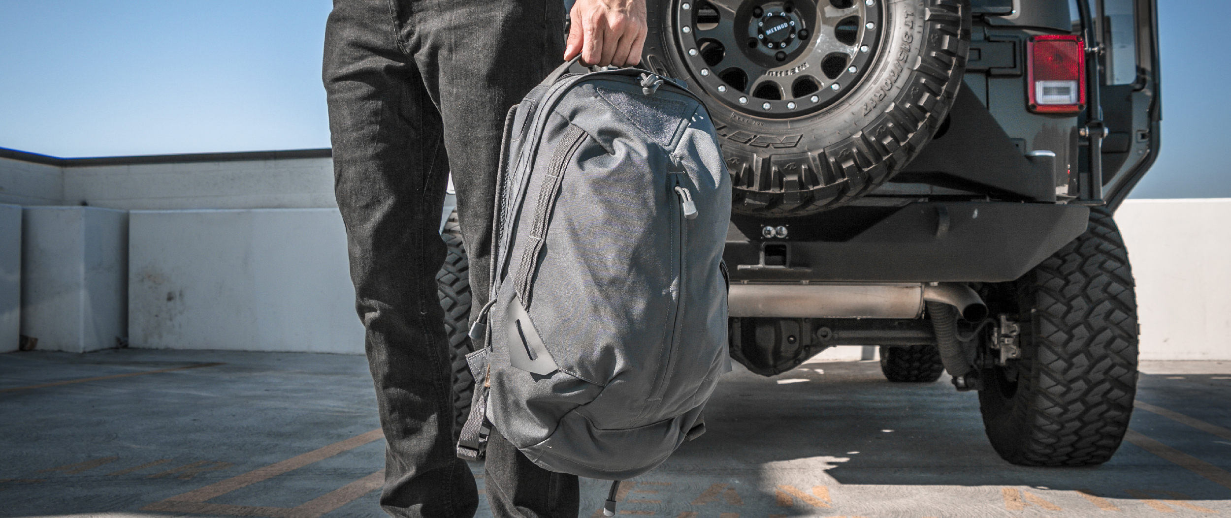 Image of someone near a jeep wearing the backpack