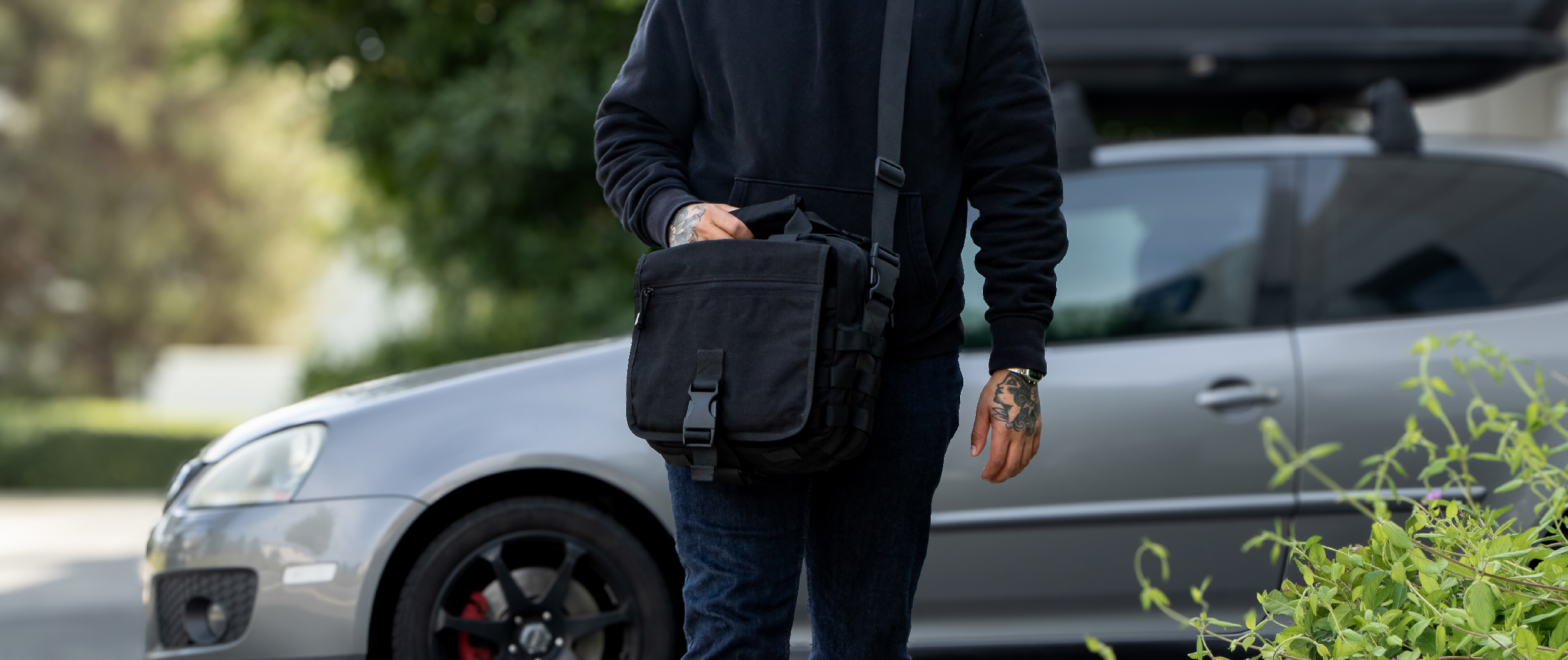 Image of a person walking away from their vehicle wearing the E & E Tactical Bag