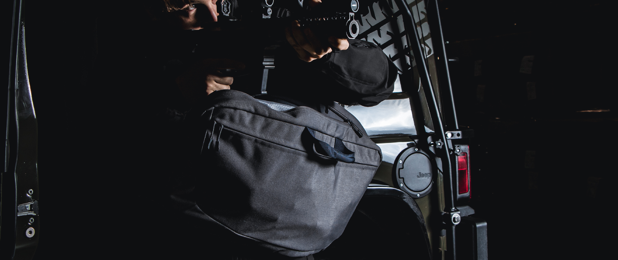 Image of the rifle bag slung and someone pointing a rifle as if they just pulled it out of the bag