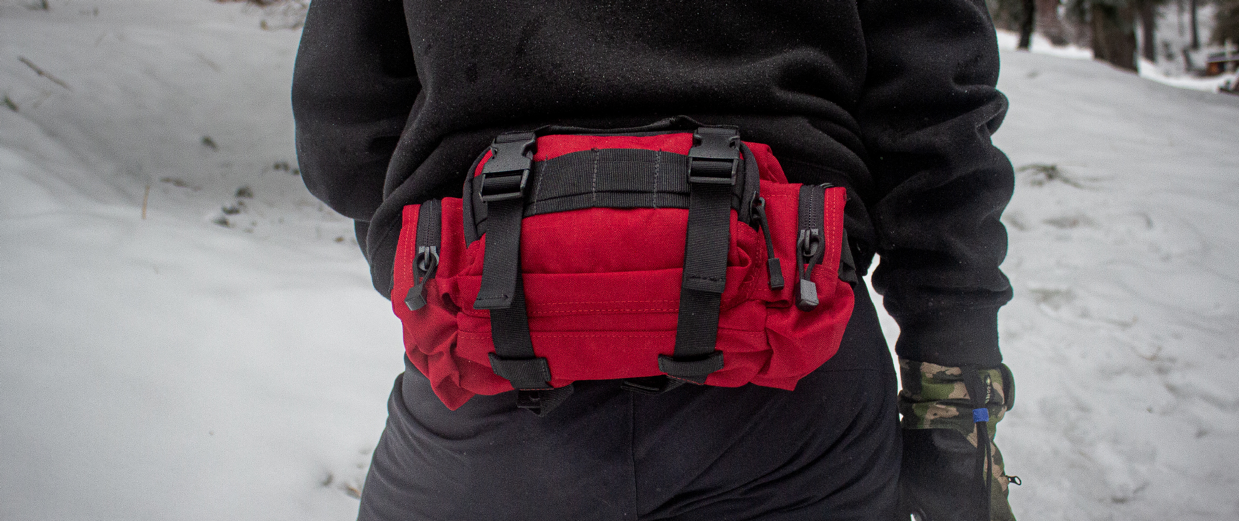 Image of someone wearing a red deployment bag in the snow