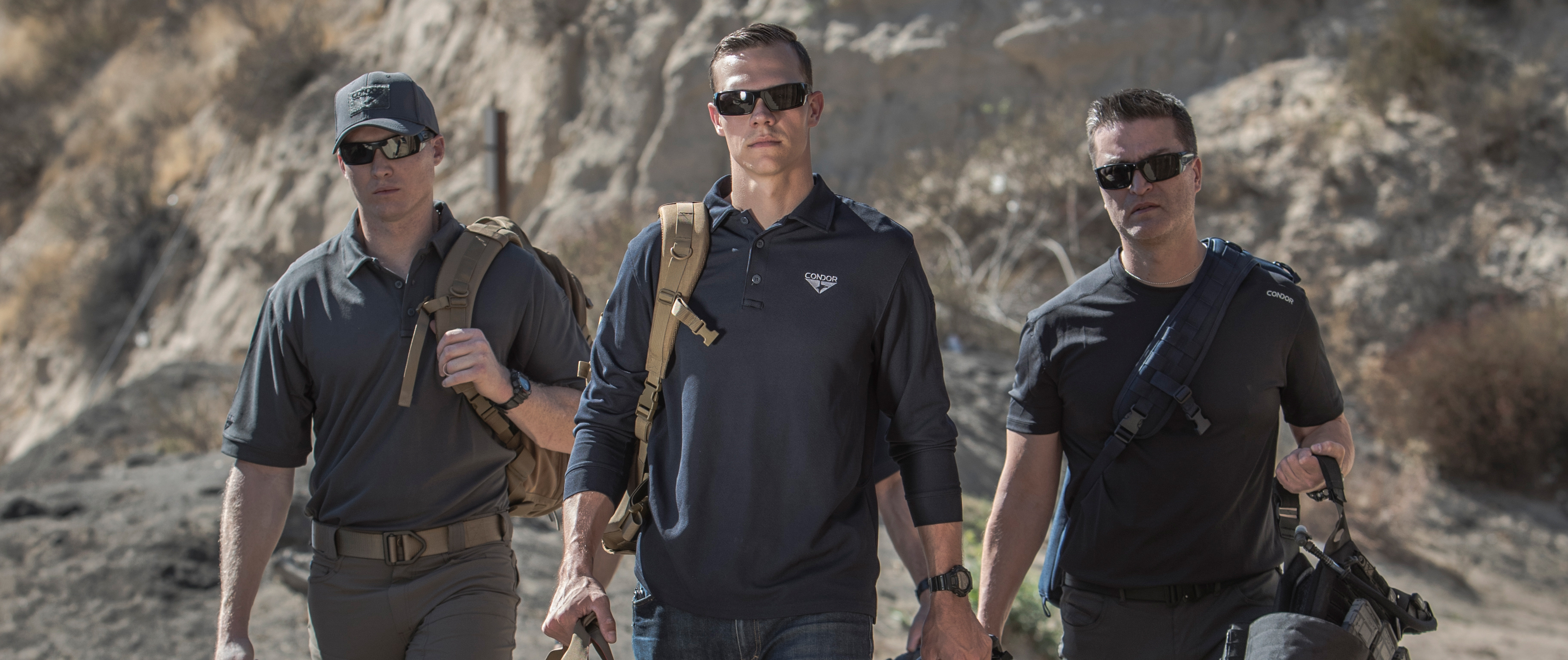 image of three people walking forward and the lead person is wearing a long sleeve tactical polo.