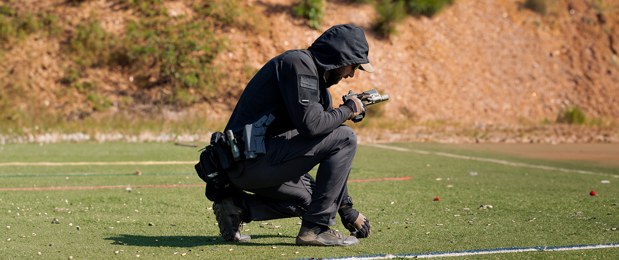 Image of someone at the range with the hood up on their tactical sun shirt