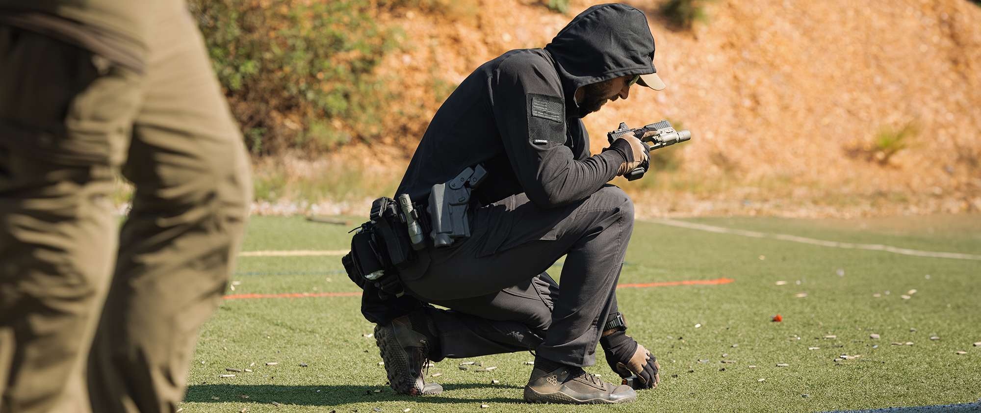 Image of someone at the range with the hood up on their tactical sun shirt