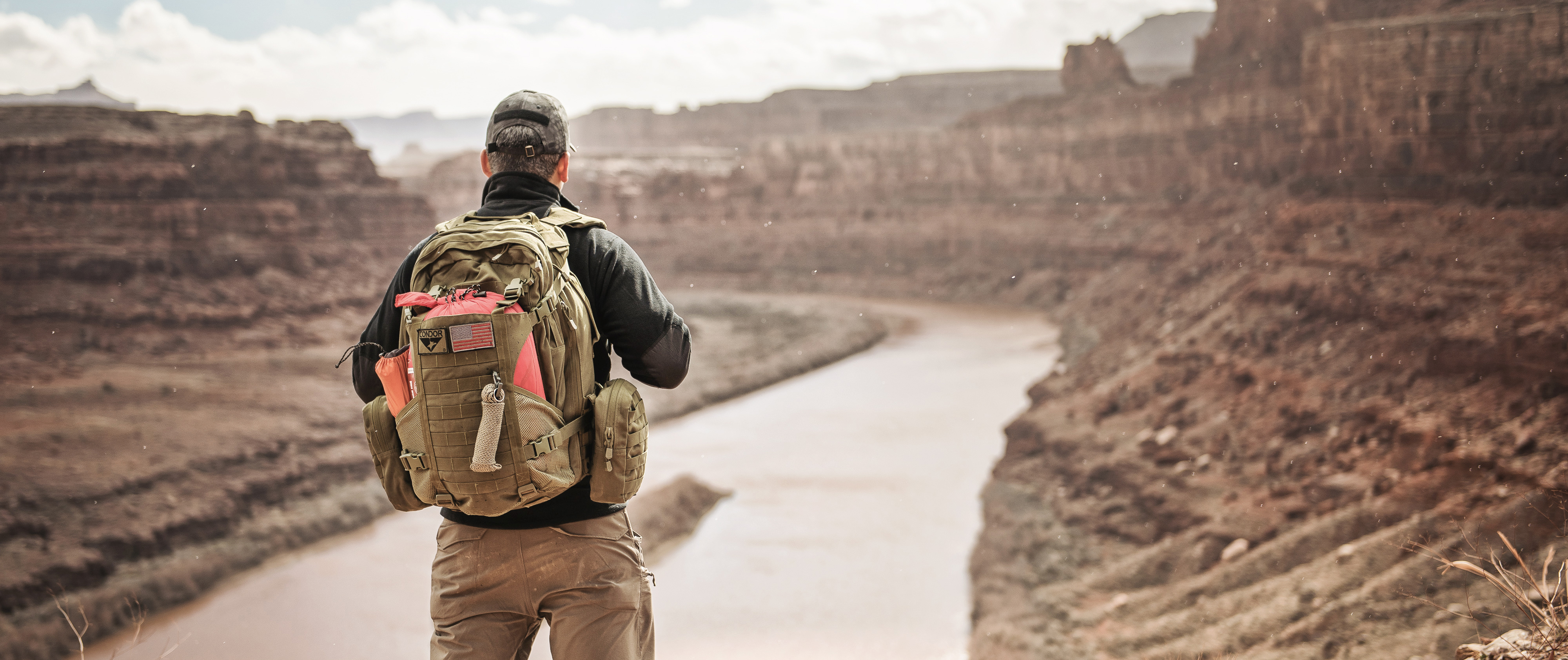 Image of a man overlooking a river in canyonlands while wearing the orion assault pack