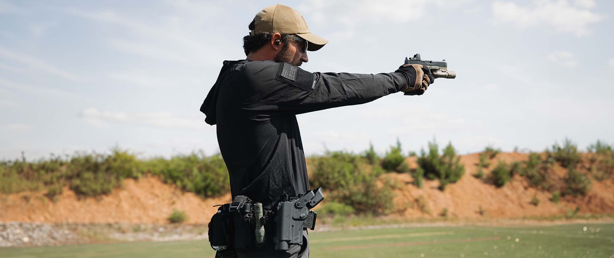 Image of someone shooting at a range with their tactical sun shirt