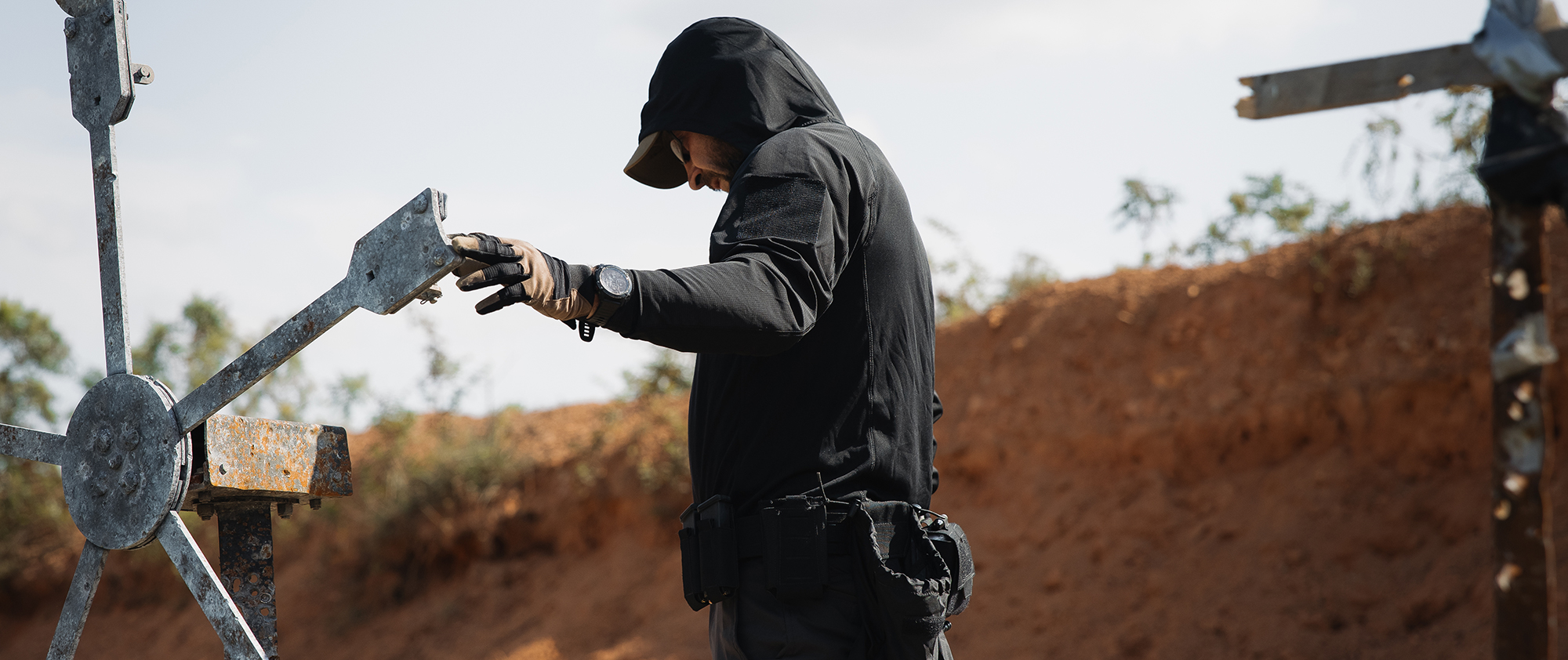Image of someone at the range adjusting targets with the hood up on their tactical sun shirt