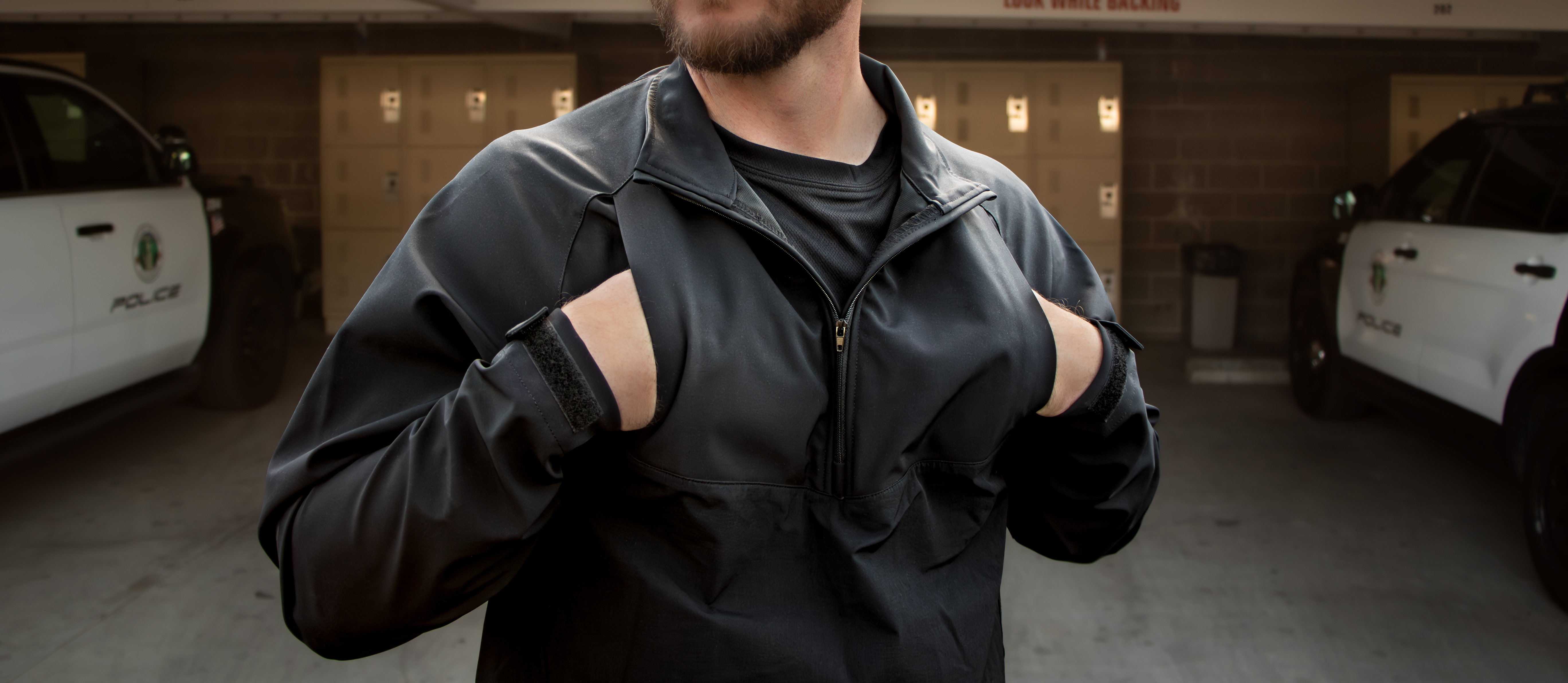 Image of a police officer with his hands in the chest pocket on the quarter zip softshell