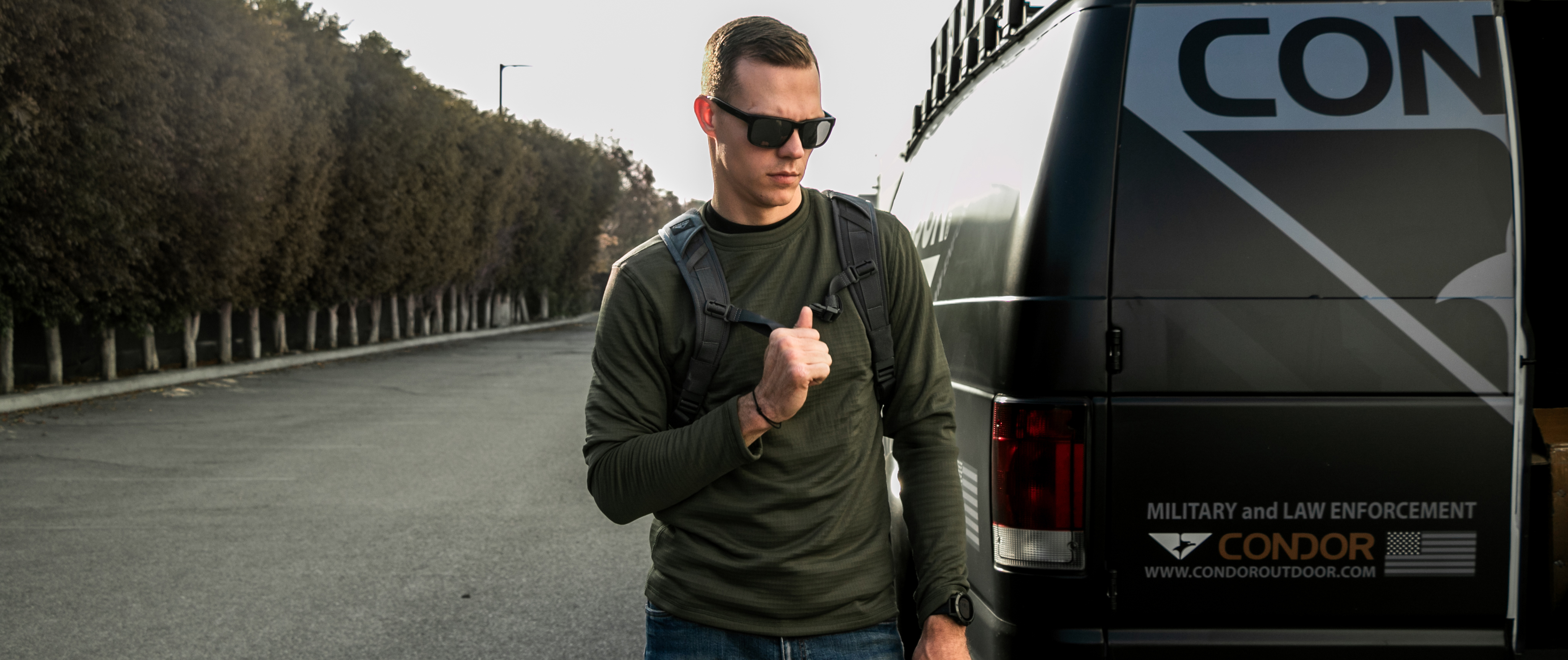 an image of a man in a crew neck waffle top standing next to a van