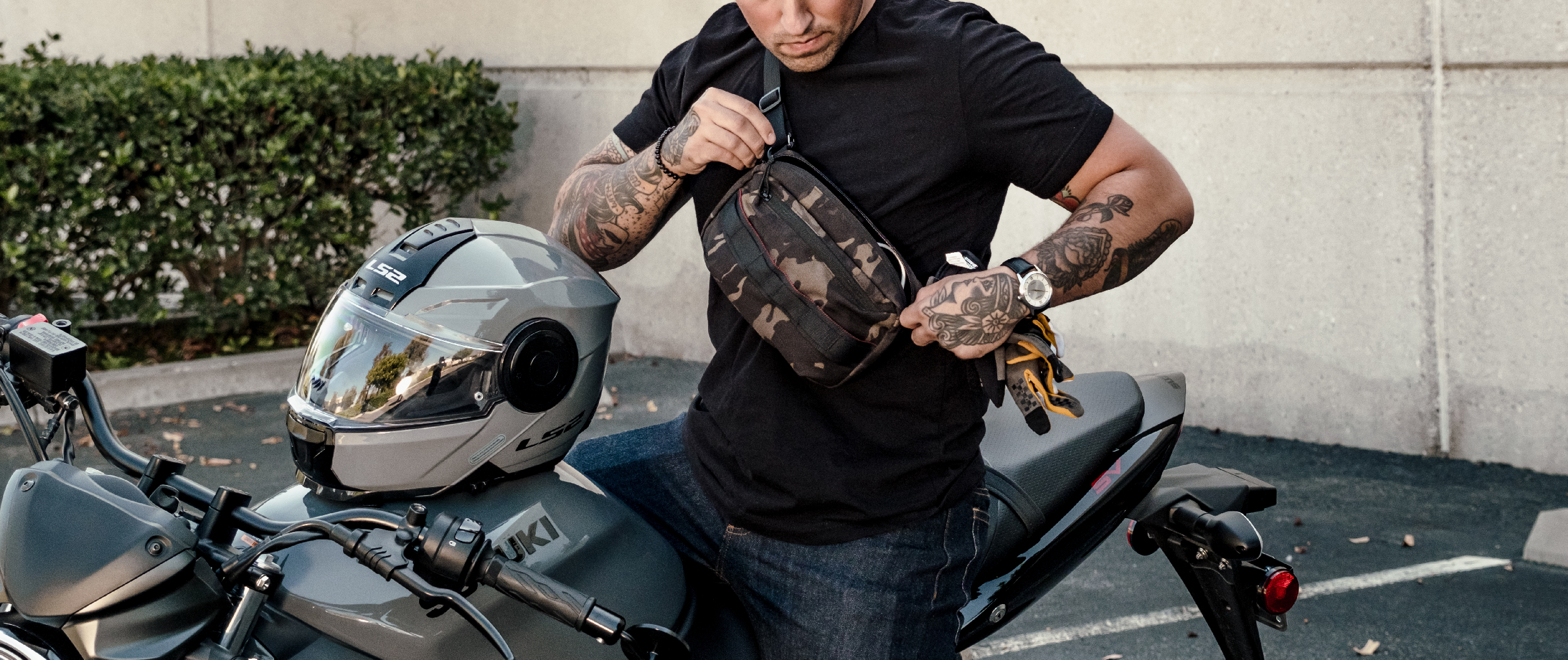 Image of the Tech pouch in multicam black being opened by a guy on a motorcyle
