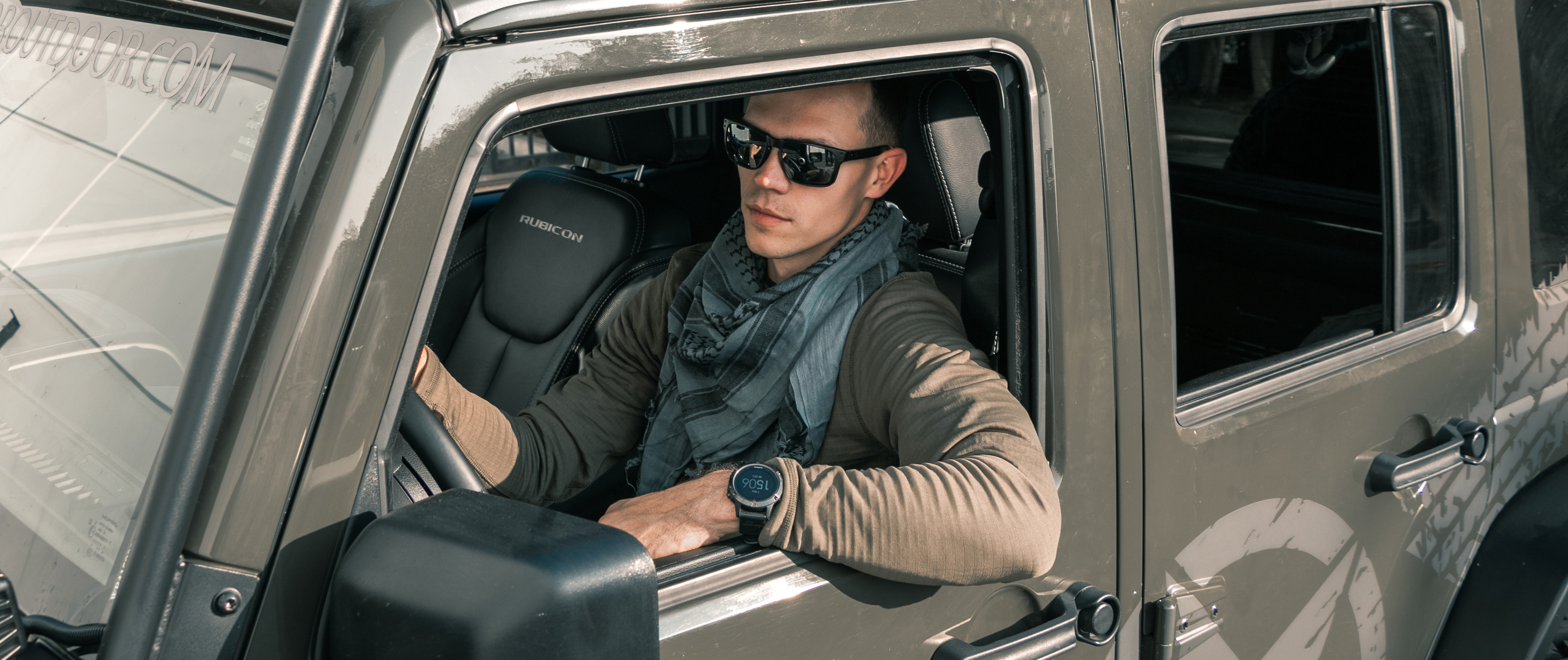 an image of a man sitting inside of a jeep drivers seat while wearing a base II crew