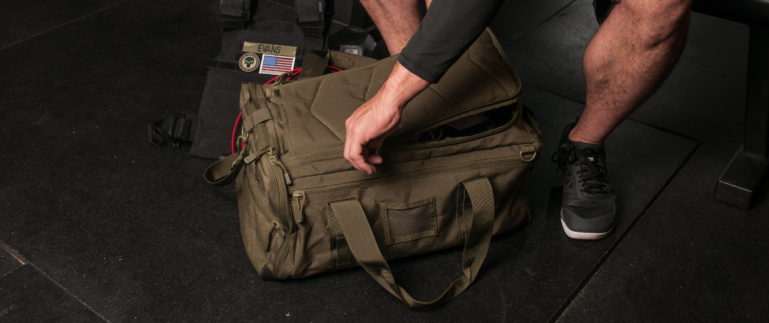 Image of someone at a gym opening the duffle at the gym